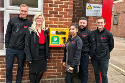 Elliotts employees with the 24-hour access defibrillator outside Elliotts Head Office