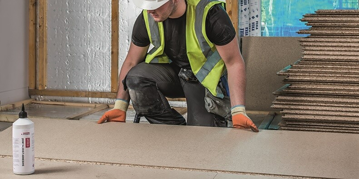 A builder installing chipboard flooring