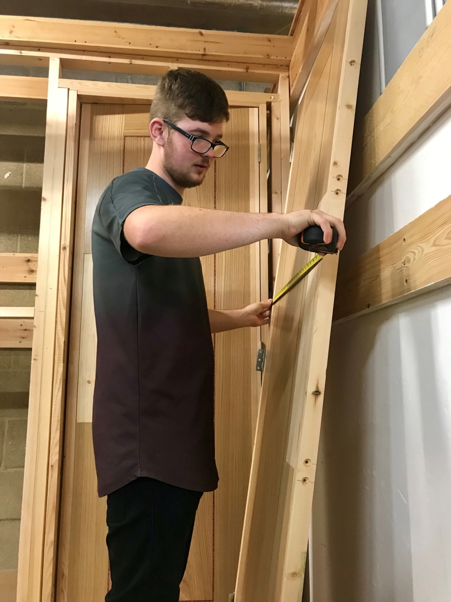 A City College student measuring up an Elliotts door